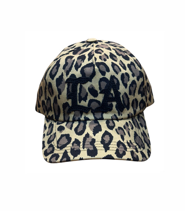 A baseball cap featuring a beige and black leopard print pattern with a black embroidered monogram 'LA' on the front, shown against a plain white background.